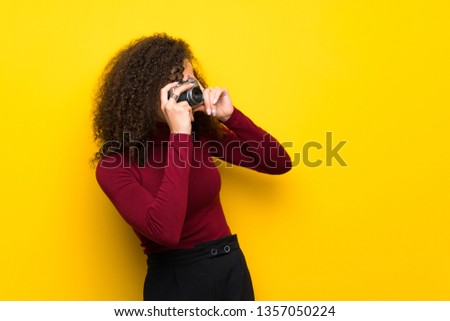 Dominican woman with turtleneck sweater holding a camera