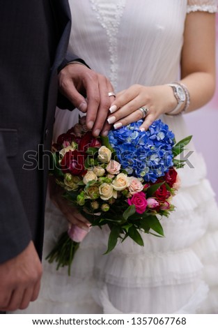 Hands of bride and groom. Close-up of wedding flower and rings Royalty-Free Stock Photo #1357067768