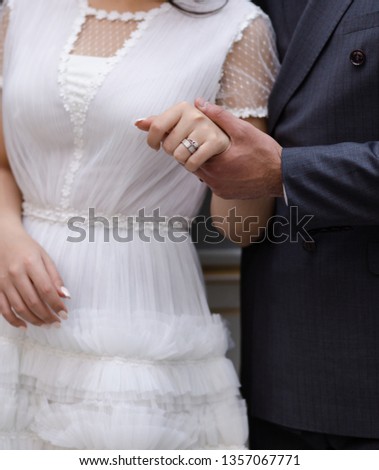 Close-up of groom's hand holding bride's wrist. Wedding rings. Royalty-Free Stock Photo #1357067771