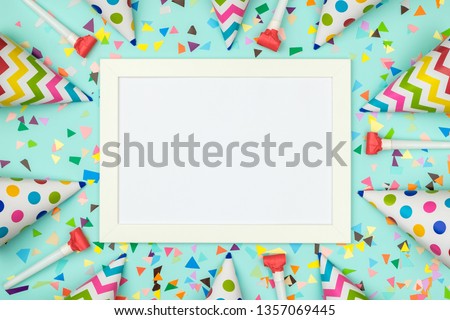 White frame on colorful table top view. Mockup for planning birthday or party. Copy space for text. Flat lay. Festive greeting background