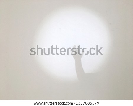 Hand and fingers gesture.Hand shadow on a white wall background. Look like to say hello or goodbye.