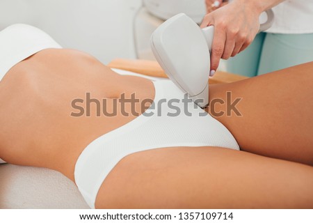 Woman having laser epilation, hair removal on bikini zone