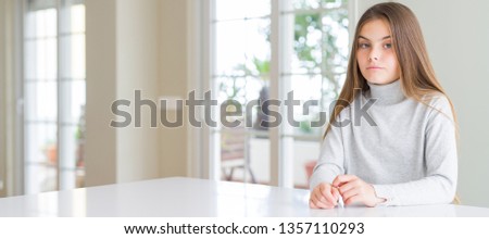Wide angle picture of beautiful young girl kid wearing casual sweater Relaxed with serious expression on face. Simple and natural looking at the camera.