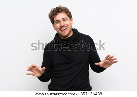 Blonde man over isolated white wall smiling