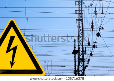 Metal high voltage danger sign and railway electric overhead contact wire all over.