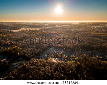 Aerial drone photo from a forresty part of Estonia with a small village hiding inside.