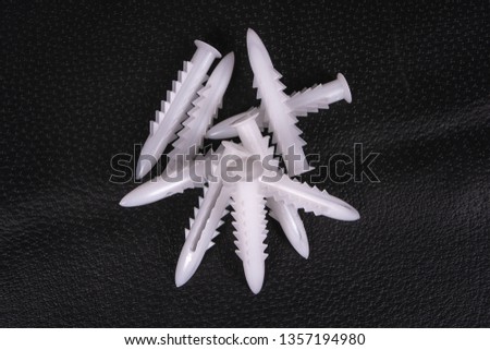 A group of plastic anchors on a black surface