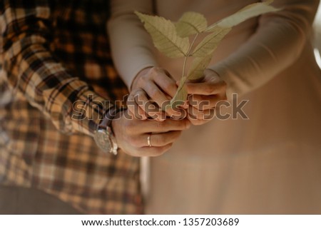 couple holding the branch of the tree with leaves together Royalty-Free Stock Photo #1357203689