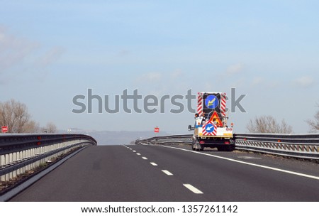 truck with big road sign with arrow on the motorway before the roadworks