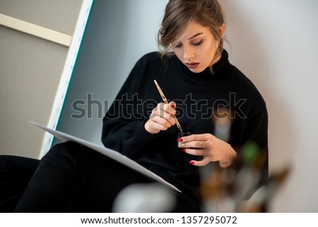 
A young woman, a student in a plastic and architectural studio, sketches and paints pictures