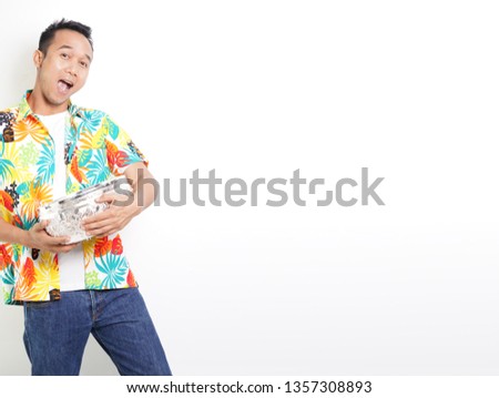 songkran festival suit. Attractive asian man with hawaii shirt  holding flower garland and water bowl for the ritual bathing of Buddha, Thailand traditional celebration of elders.  