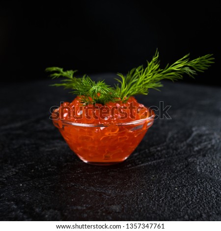 Red Caviar in bowl over black background