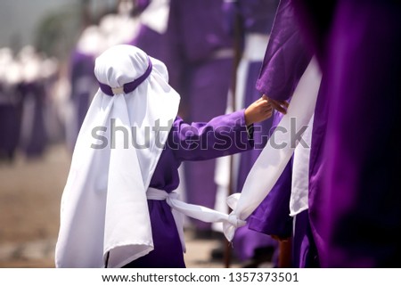 Father and son in the line of penitents (Cucuruchos) in the streets to accompany the procession of La Merced, Antigua Guatemala. Royalty-Free Stock Photo #1357373501