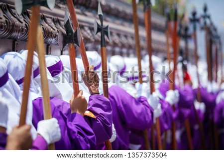 ¨Cucuruchos¨ (penitents) carrying on shoulders the heavy wooden float of the procession of La Merced, Antigua Guatemala during Good Friday. Royalty-Free Stock Photo #1357373504