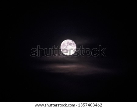 Bright and full moon with surrounding clouds