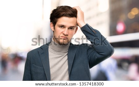 Teenager man with turtleneck with an expression of frustration and not understanding at outdoors