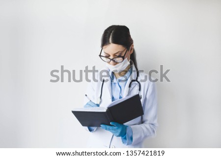 Doctor female reading a medical book in her office - Image
