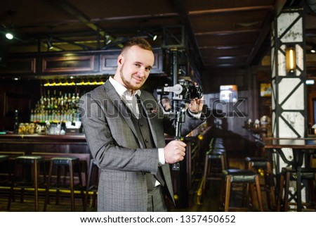 Fashionable videographer shoots the clip in a luxury restaurant. Shooting a video clip in a pub