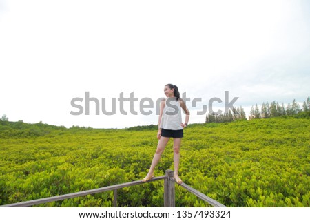 Perrty woman standing at field with lovely smile.
