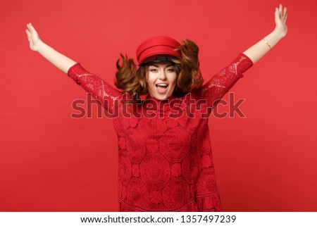 Portrait of cheerful pretty young woman in lace dress, cap jumping with spreading hands isolated on bright red wall background in studio. People sincere emotions lifestyle concept. Mock up copy space