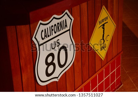 Surfer xing yellow sign and California route sign