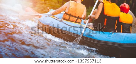 Close-up of young people rafting on the river turbulent flow with sunbeam. Extreme and enjoyment sport. Royalty-Free Stock Photo #1357557113