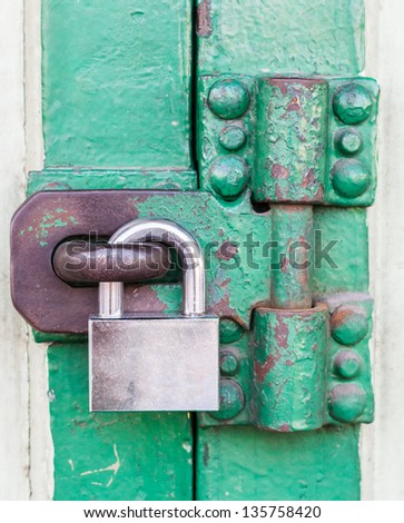 Old wooden doors are locked with a metal padlock.