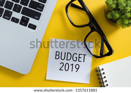 Budget 2019 concept on desktop with laptop keyboard and office supplies.