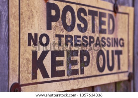 Posted No Trespassing Keep Out Sign on a Fence