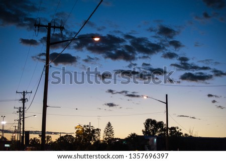 Sunrise in the town of Lightning Ridge creating silhouttes of the street lights, poles and power lines