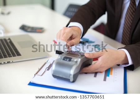 Businessman hand with credit card swipe through terminal