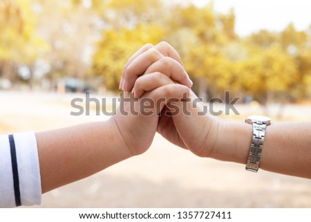 Children and mothers relax in the holiday ,garden, holding hands, symbols.