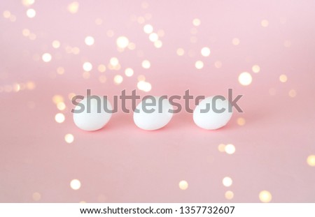 Festive easter background. White eggs on pastel pink background with blur effect. Close up, copy space.