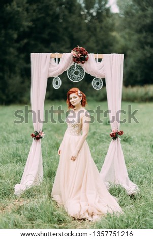 Bride in a field of tall grass. Wedding photo shoot in nature in European style.
