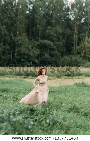 Bride in a field of tall grass. Wedding photo shoot in nature in European style.