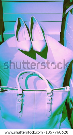 Concept of trendy female accessories bag shoes on empty boxes and neon pink violet green background. Elegance fashion outfit. Minimal lifestyle concept. Selective focus, duotone effect. Copy space.