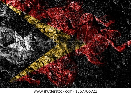 East Timor smoky mystical flag on the old dirty wall background