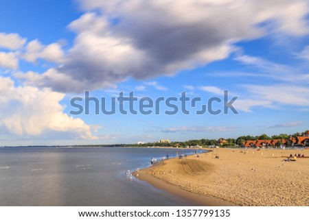 sand beach under clouds with blue sky in Baltic sea, Sopot, Pomerania, Poland, seen from Sopot Pier, the longest wooden pier in Europe. 