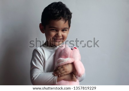 Portrait of 4-5 years adorable old boy playing with soft plush cute rabbit bunny toy