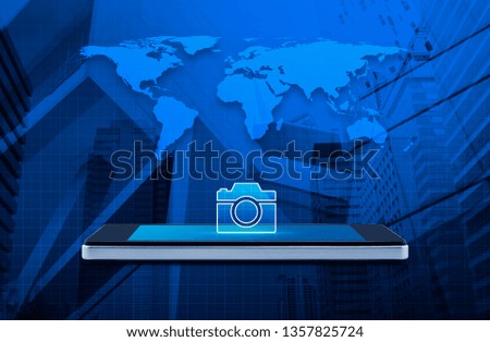 Camera flat icon on modern smart mobile phone screen on wooden table over world map, office city tower and skyscraper, Business camera shop online concept, Elements of this image furnished by NASA