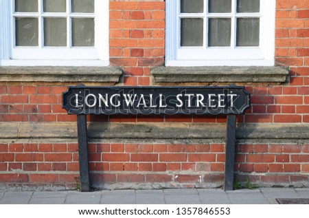 cast iron traditional street sign labelling Longwall Street in Oxford, England opposite Magdalen College and near New College in Holywell Street