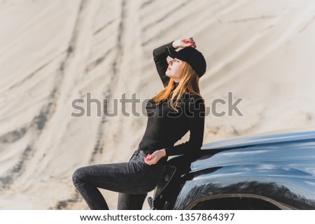 Woman wear black turtleneck, jeans and baseball cap, girl in sand desert. Fashionable casual style, fashion and clothes concept of modern look