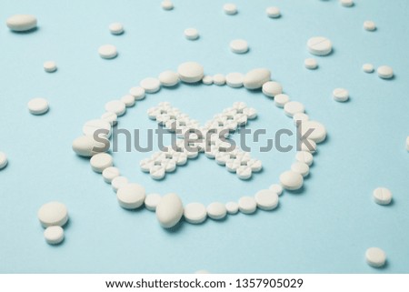 Stop symbol made of white pills on blue background. Medical care, ambulance.