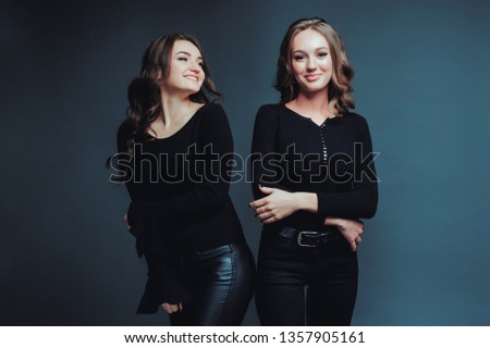 Women two smiles communication friendship evening love relationship joy black background studio. Blue cyan toned photo.