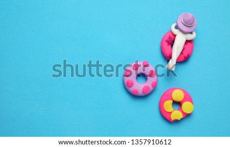 Plasticine people relaxing on inflatable donut lilo in pool. Cartoon summer relaxing and holidays.