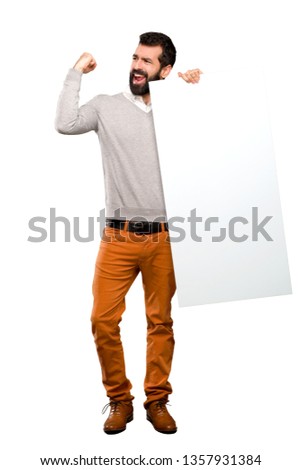 Happy Handsome man with beard holding an empty placard over isolated white background