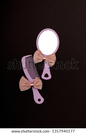 Hairbrush and mirror isolated on black copy space background. Mininmalistic feminine flat lay.