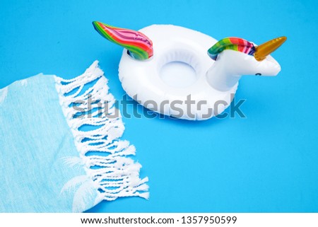 Inflatable unicorn And Towel On Blue Background Royalty-Free Stock Photo #1357950599