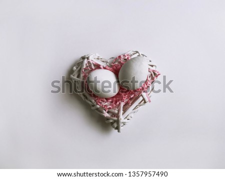 Shabby white heart of wooden rods with two Easter eggs, wooden frame, white openwork bird cage. Top view of a refined and refined Easter stylish still life