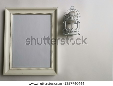 Shabby white wooden classic frame with Easter eggs, white openwork bird cage. Top view of a refined and refined Easter stylish still life